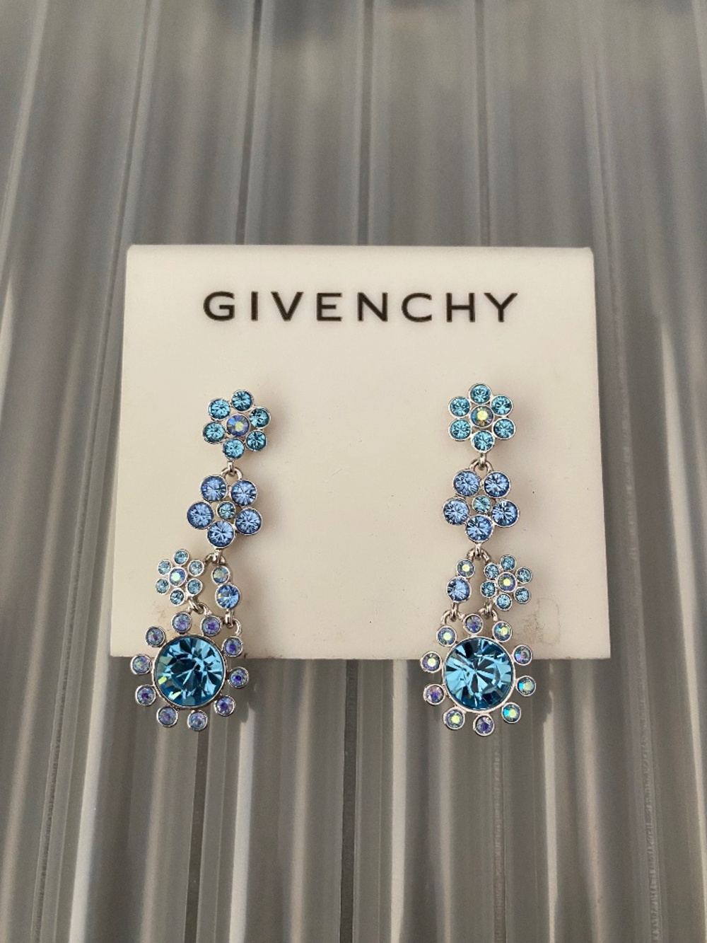 These Givenchy silver-tone earrings feature a floral design w/ blue crystal